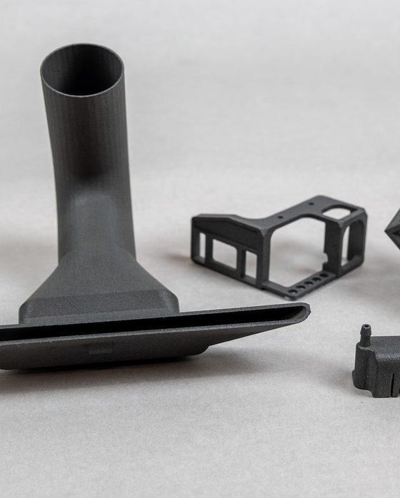 SLS Nylon 12 parts: a dust nozzle, a camera cage bracket and a lattice cube